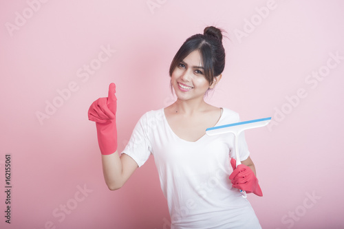 Beautiful asian housewife smiling on pink background