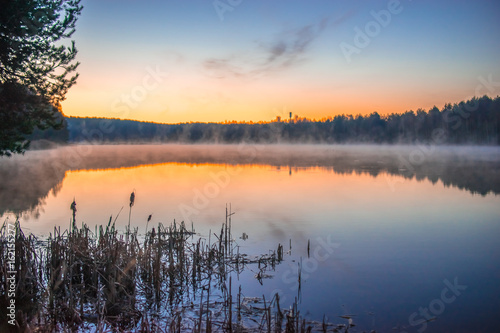 Sunrise on a small lake near forest