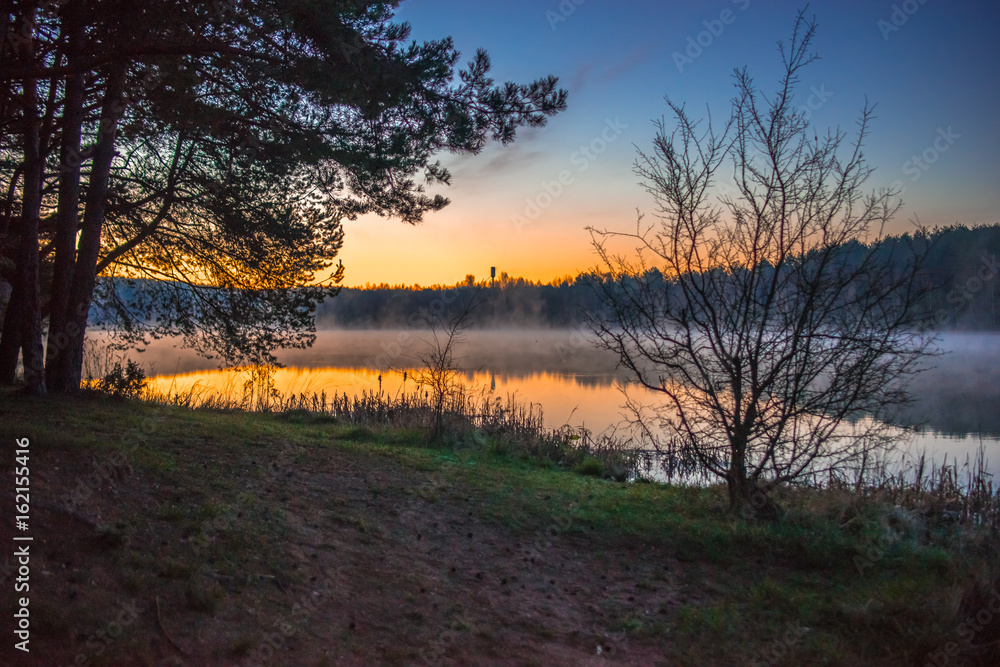 Sunrise on a small lake near forest