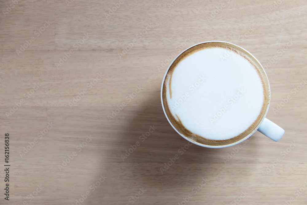 Hot cappuccino in white cup on wooden table with copy space Hot cappuccino in white cup on wooden table with copy space
