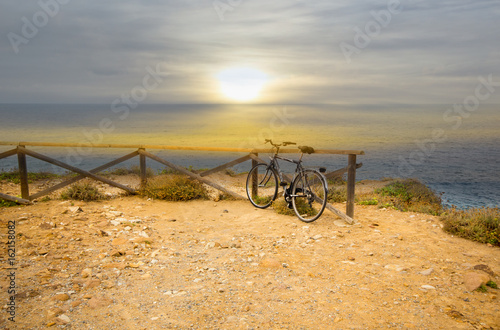 Fototapeta Naklejka Na Ścianę i Meble -  Blurred image. Bicycle parked on the beach with sun rise in vintage tone style.
