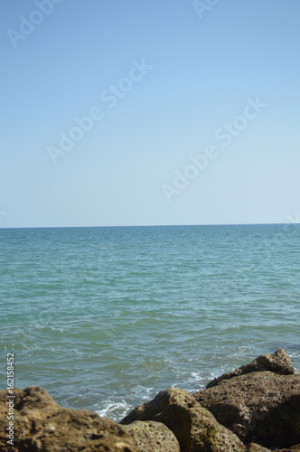 Sunny panoramic view of the ocean with rocks, seascape natural outdoors background