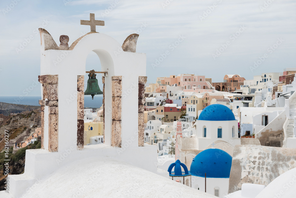 Belfry with blue domes of churches in Oia, Santorini, Greece
