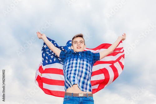 USA flag is held by a running guy in the background of a summer sky