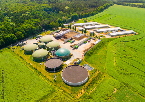 Aerial view over biogas plant and farm in green fields. Renewable energy from biomass. Modern agriculture in Czech Republic and European Union. 