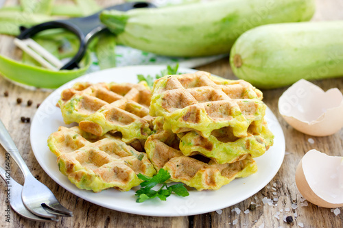 Zucchini waffle, zucchini fritters cooking on waffle maker, vegetarian zucchini pancakes