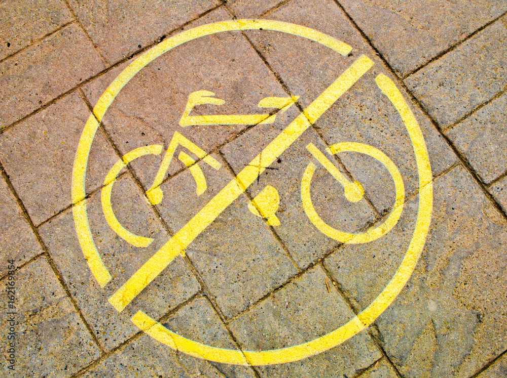 painted yellow sidewalk sign prohibiting bicycles