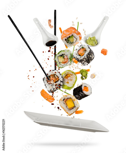 Sushi pieces placed between chopsticks on white background