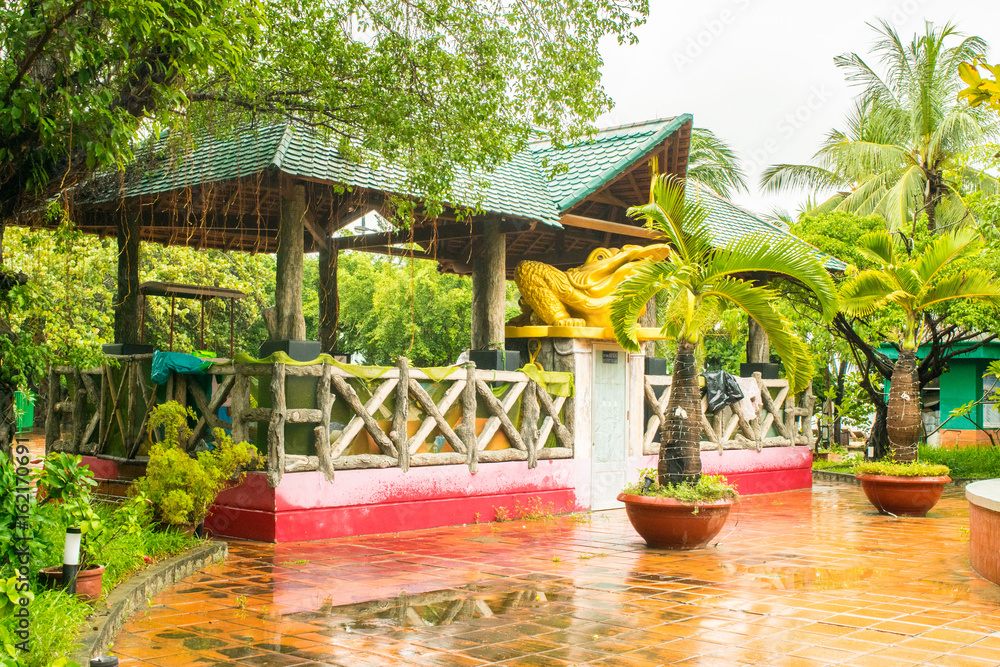 Park Gorkogo at Nha Trang, Vietnam - pavilion decorated by golden statue of a frog with a coin and palms in pots