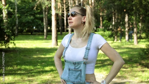 An angry woman looks at the clock. The girl is waiting for someone, looks at the clock and is angry. photo