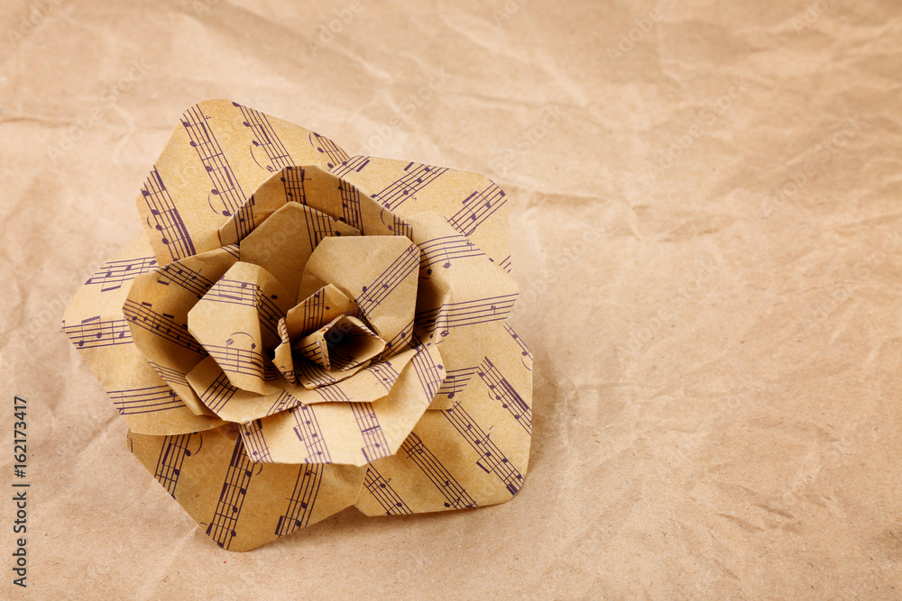 Fototapeta premium Beautiful rose made of music notes on textured paper closeup