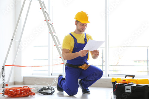 Young electrician checking ...