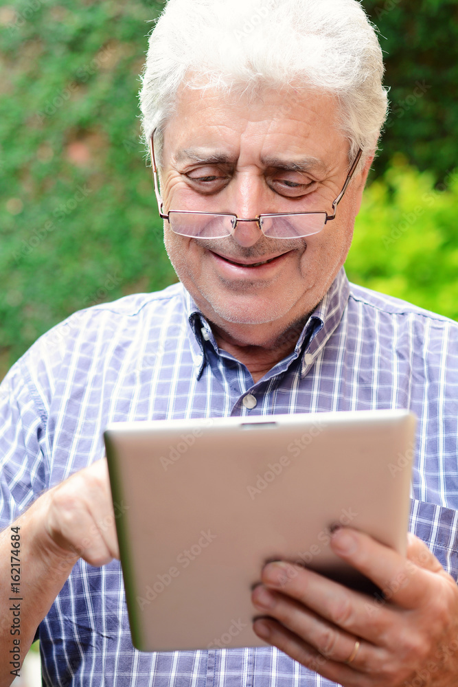 Old man using digital tablet. Old man using digital tablet.
