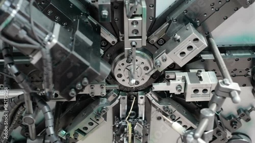 Automatic CNC bending machine. Manufacturing of a torsion spring. Cold industrial color. Pan left to right