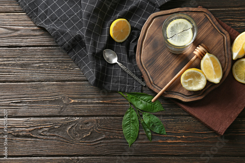 Composition with cold lemon water on wooden table