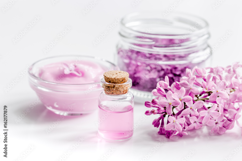 spa cosmetic set with lilac flowers white desk background spa cosmetic set with lilac flowers white desk background
