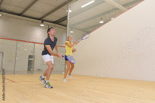 couple enjoying a game of squash in the squash court