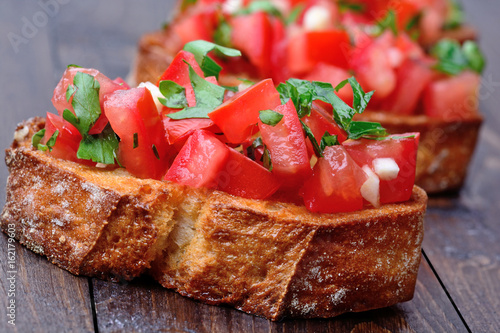 Bruschetta with tomatoes and garlic on table