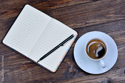 Empty notepad with coffee cup on table