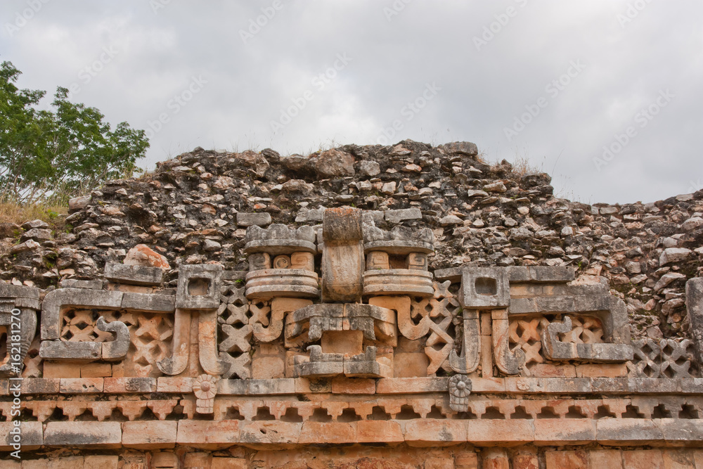 glyphs and mask in Yucatan ruins, Mexico