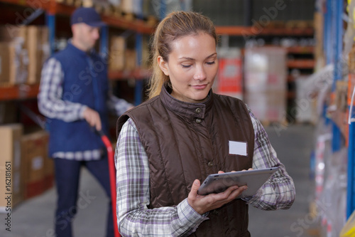 warehouse manager using tablet pc in a large warehouse