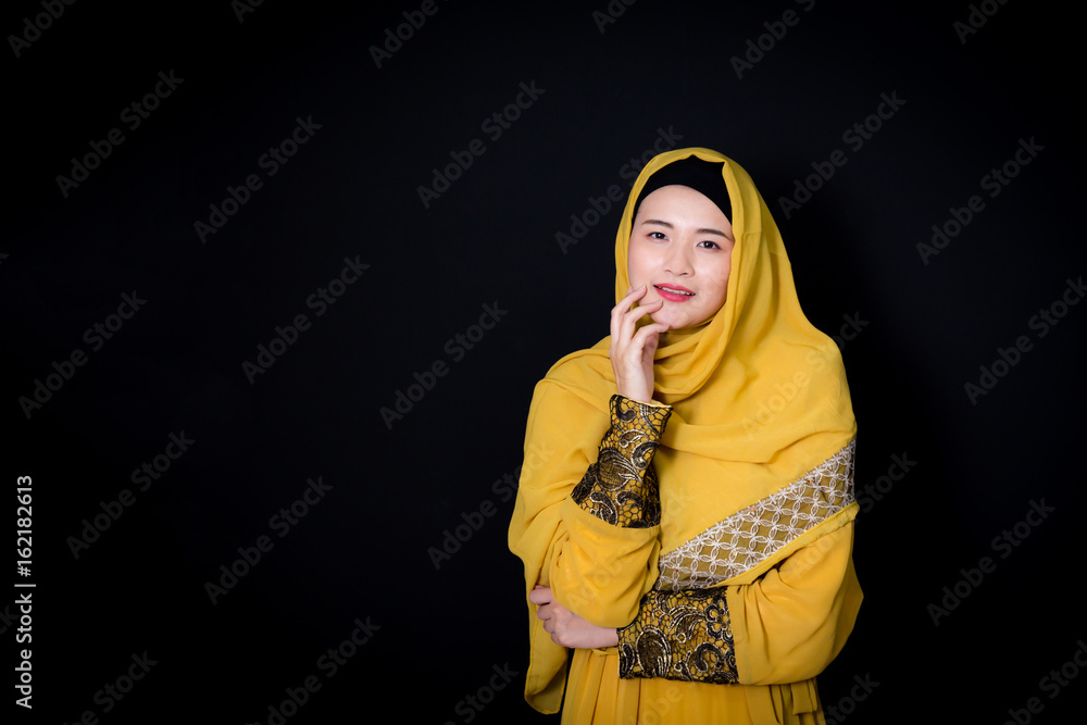 Naklejka premium Portrait of beautiful muslim asian woman over black background with happy muslim woman, Age 20-30 years.