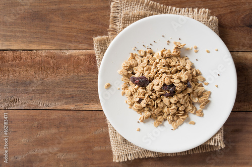 Cereal in white plate on wooden background.