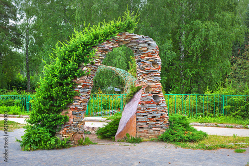Billede på lærred Garden arch in stone the conifers