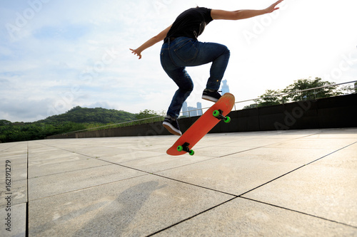 young woman skateboarder skateboarding at city