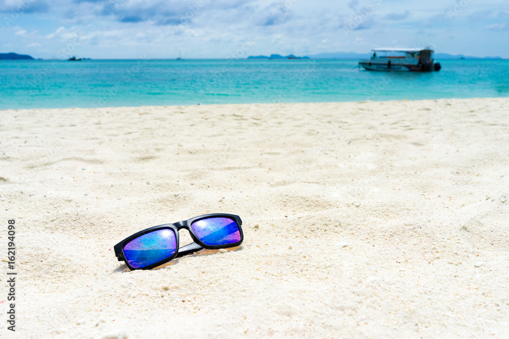 Sun glasses on the white sand at the beach of lipe island,turquoise Ocean beach relax, outdoor travel