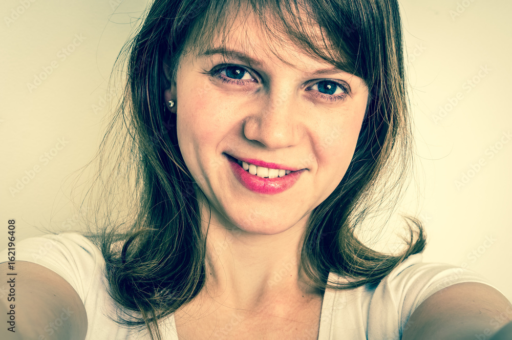 Naklejka premium Young smiling woman making selfie