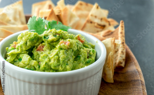Guacamole close-up view. Guacamole is a avocado based dip, traditionally a mexican (Aztecs) dish. Healthy and easy to make at home with a few simple ingredients. Excellent as party food or at bars.