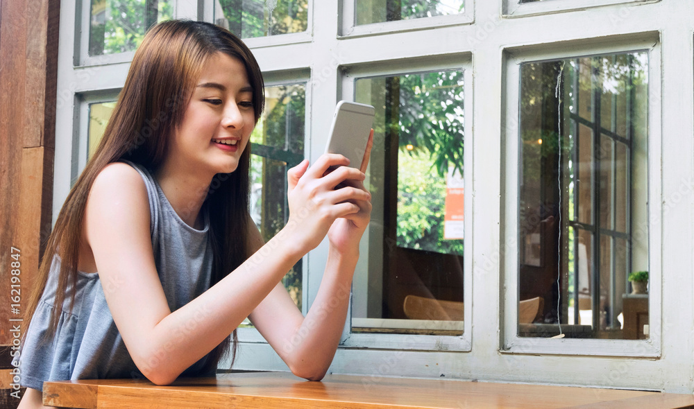 Asian women use smartphone in cafe shop. Asian women use smartphone in cafe shop.