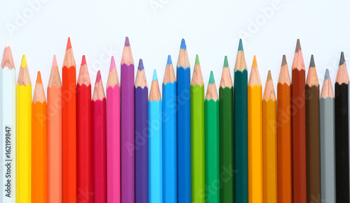 colored pencils row with wave on white background.