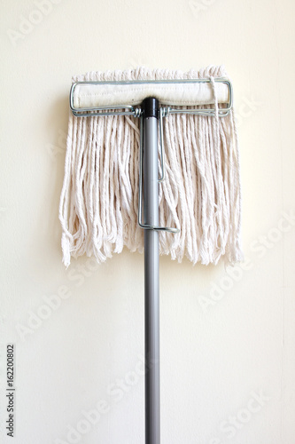 Mop placed on the white wall.