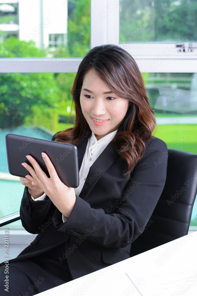 Young Asian businesswoman using tablet computer Young Asian businesswoman using tablet computer