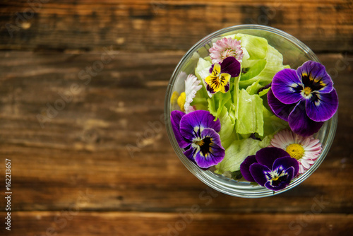 Fresh green salad with herbs and garden flowers. Healthy food concept