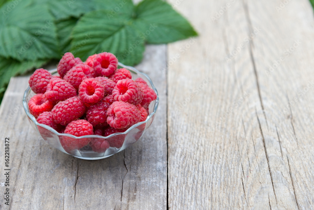 red raspberries in bowl on wooden background red raspberries in bowl on wooden background
