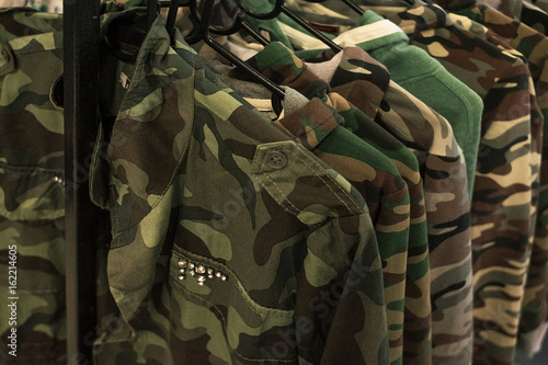 Jacket military style hanging on clothes rack. photo