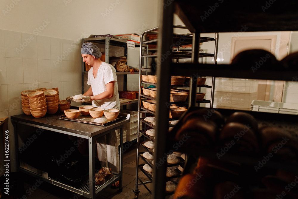 male cook shaping dough for baking bread