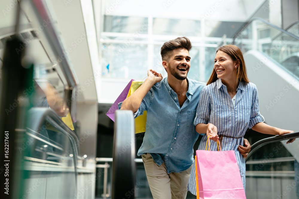 Happy attractive loving couple enjoy shopping together