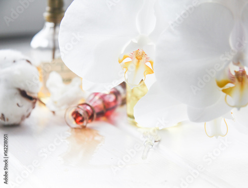 perfume and flowers cotton and white Orchid on white wooden table