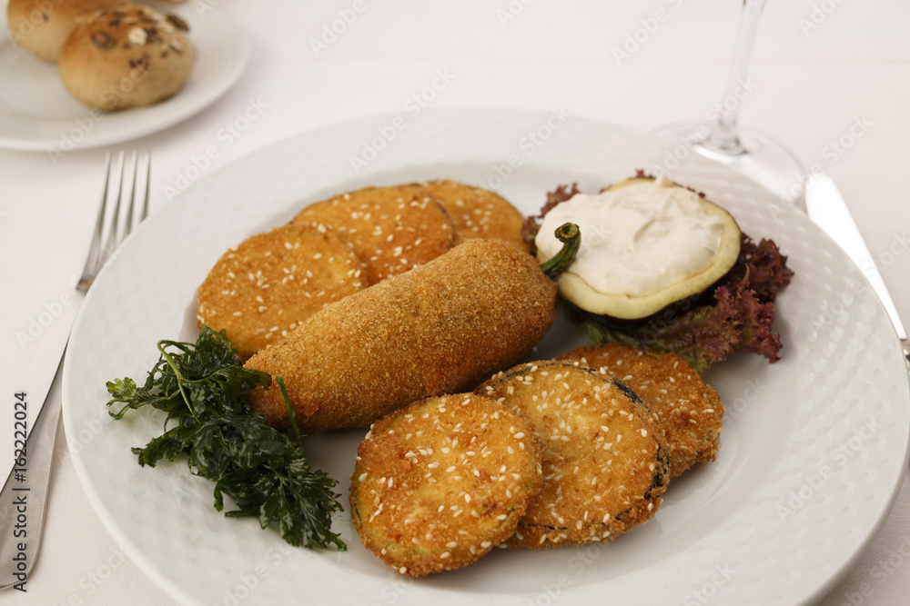Breaded and fried red bell pepper and eggplant arranged on a plate, Traditional dish in elegant setting, Selective focus with soft light Breaded and fried red bell pepper and eggplant arranged on a plate, Traditional dish in elegant setting, Selective focus with soft light