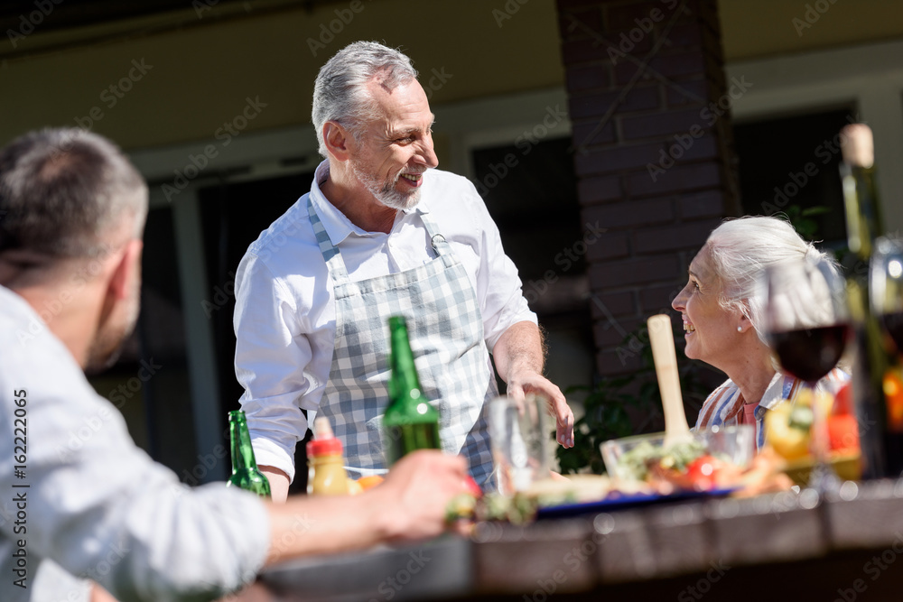 happy family talking during lunch on patio at daytime happy family talking during lunch on patio at daytime