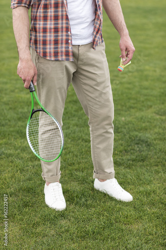 Cropped shot of man holding badminton racquet and shuttlecock and ready to play