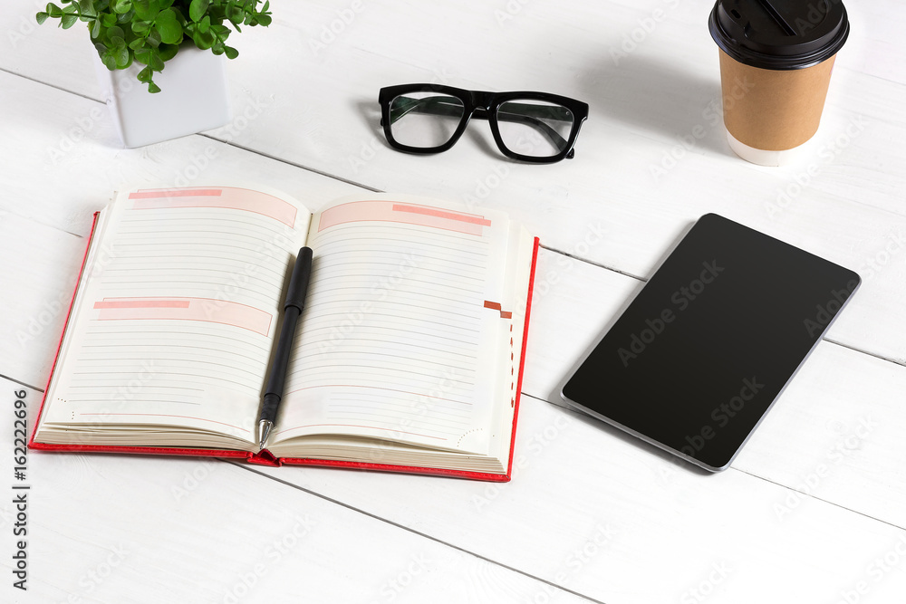 Stylish minimalistic workplace with tablet and notebook and glasses in flat lay style. White background. Stylish minimalistic workplace with tablet and notebook and glasses in flat lay style. White background.