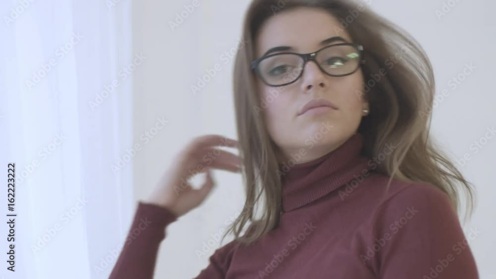 Portrait of attractive young woman in the red sweater with glasse turning, possing and smiling on camera. Portrait of attractive young woman in the red sweater with glasse turning, possing and smiling on camera.