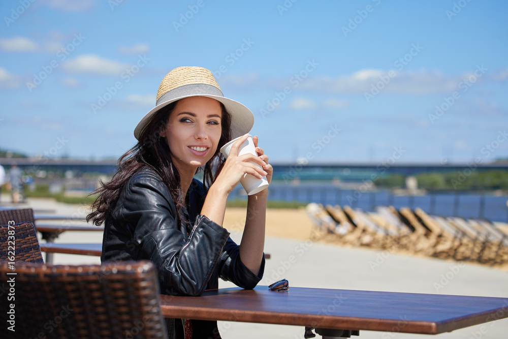 Attractive woman drinking coffee in outdoor cafe