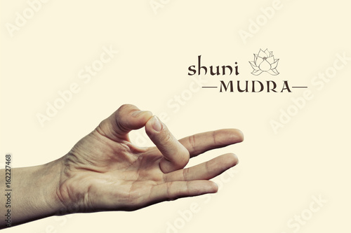Shuni mudra. Yogic hand gesture. Isolated on toned background.