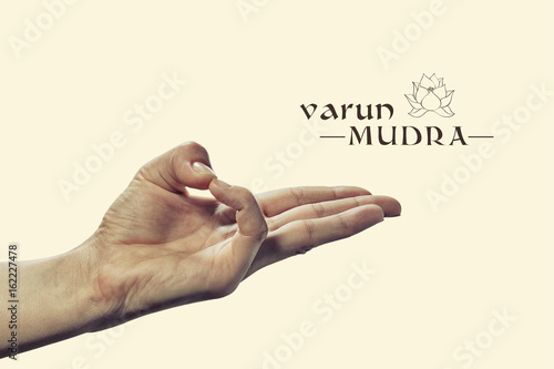 Varun mudra. Yogic hand gesture. Isolated on toned background. photo